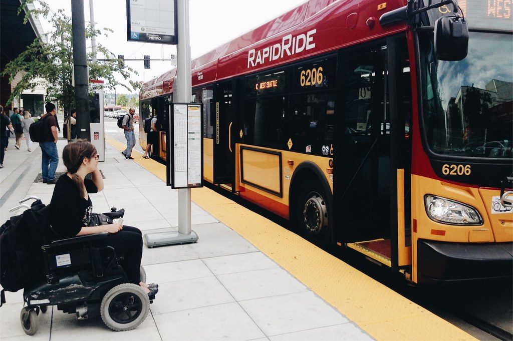 Female wheelchair user getting ready to board a public bus